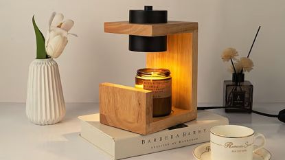 A wooden candle warmer on a pile of books